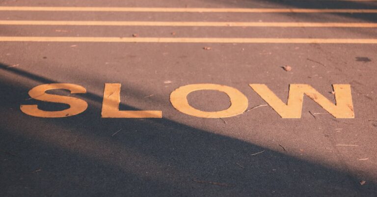 Close-up of a road with a slow sign in yellow, capturing a calm street scene in Singapore.